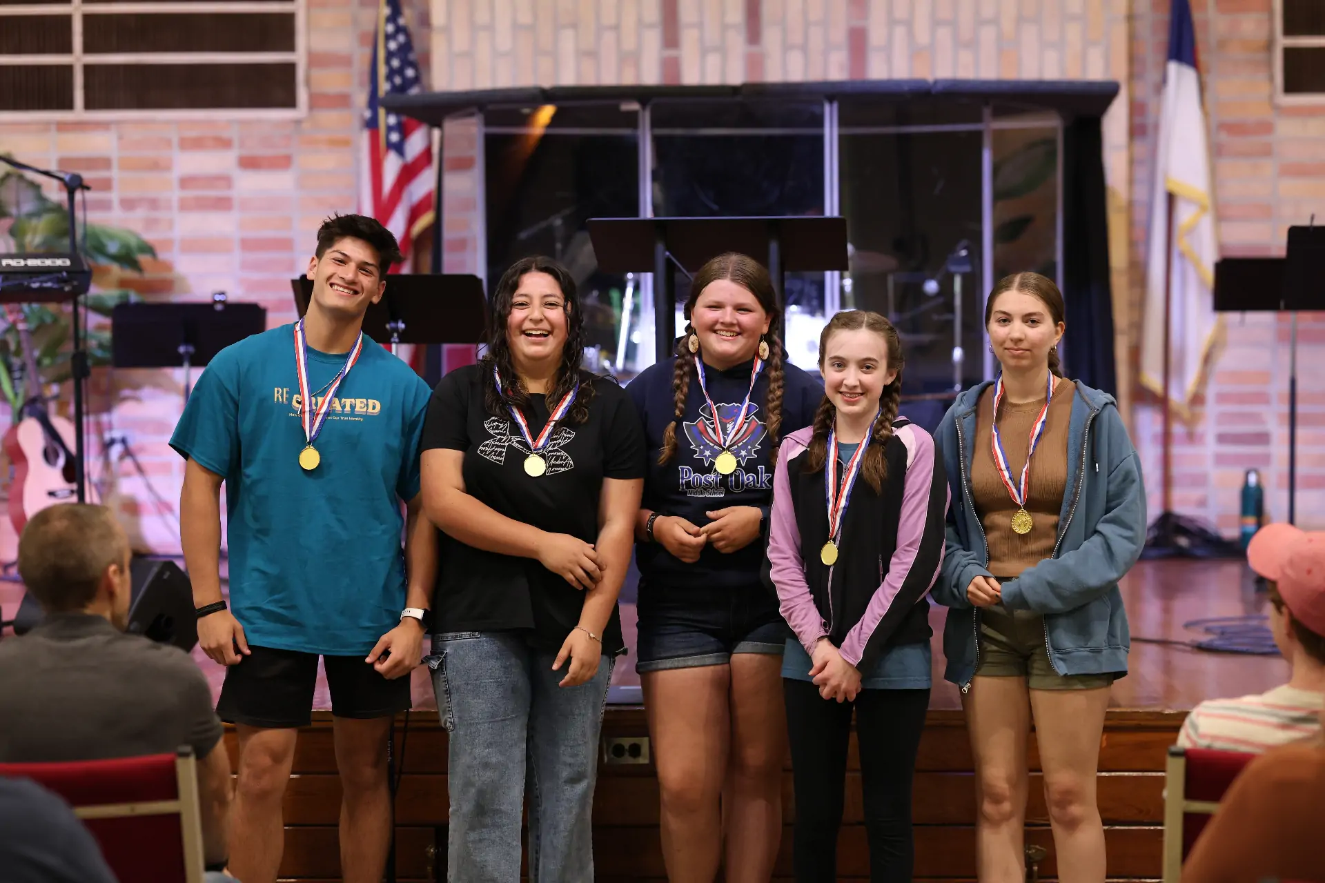 Young people smiling together with medals they won from a game